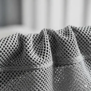 Nahaufnahme der atmungsaktiven Stofftextur eines Kinder-Bettgitters, die die sanfte und sichere Oberfläche hervorhebt.